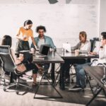 Company meeting at desks and on laptops
