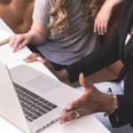 2 women sitting near a laptop during a leadership coaching session